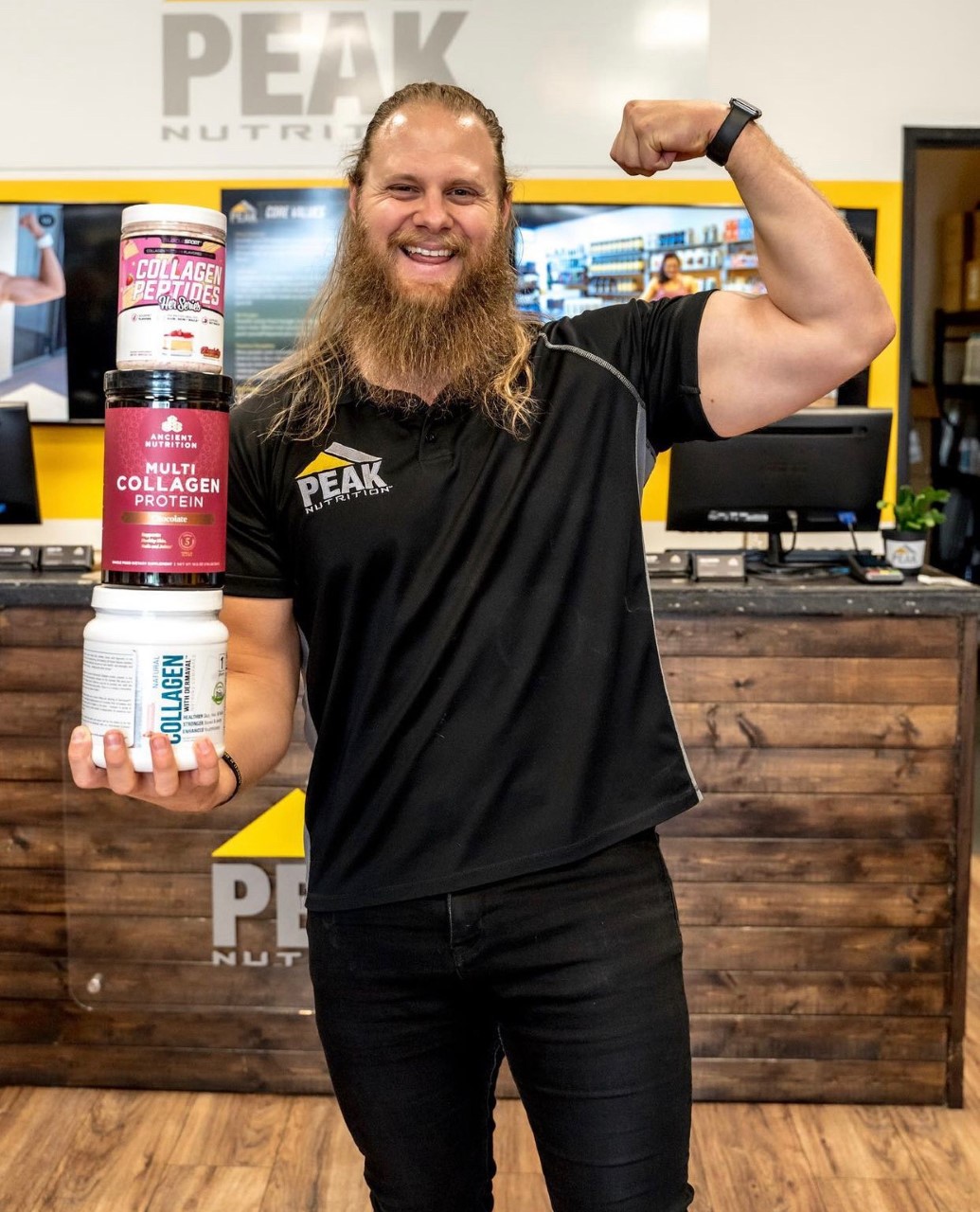 Guy in Peak Nutrition Store Holding Collagen Supplement